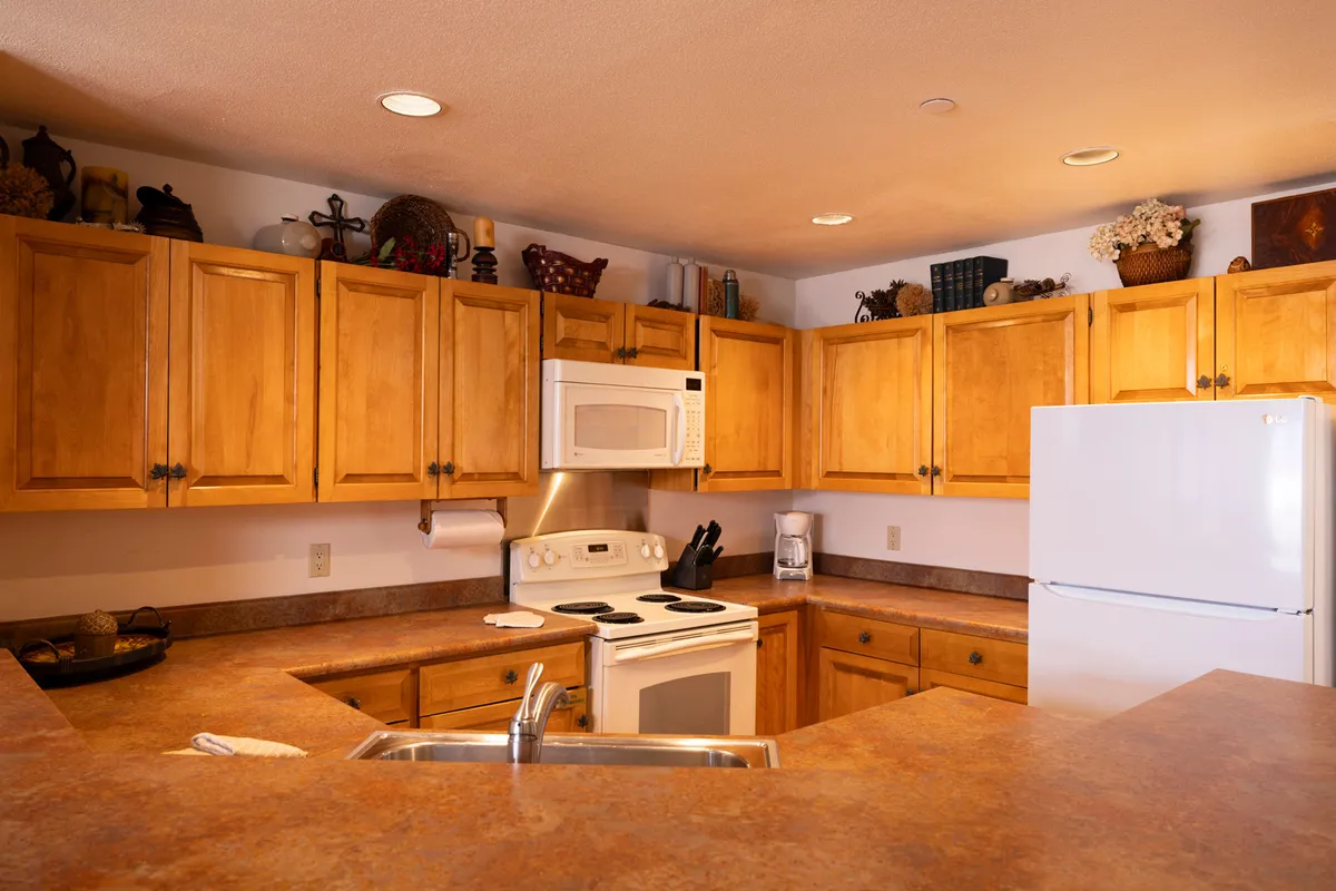 A homey kitchen space with wooden cabinets, modern appliances, and an organized countertop. The layout encourages cooking and entertaining, making it easy to imagine preparing meals before enjoying them together.